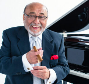 A man in a suit and tie holding a cigar.