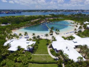 A resort with a pool and beach in the background.