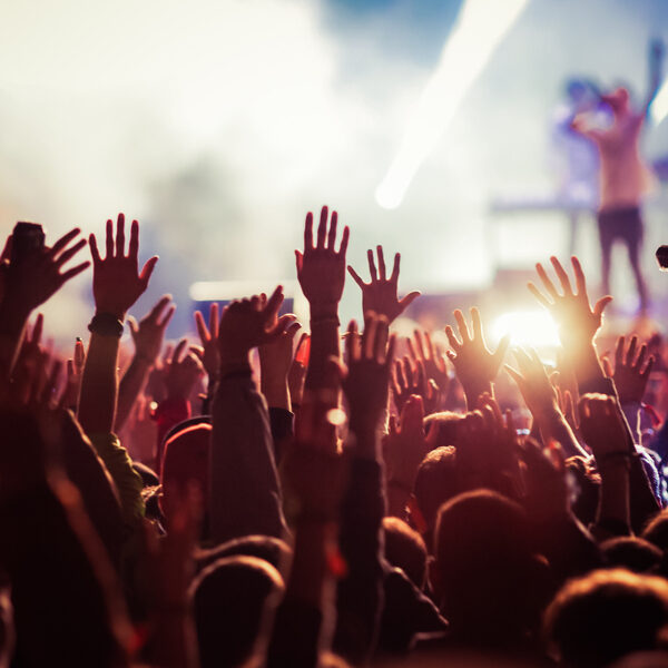 A crowd of people raising their hands in the air.